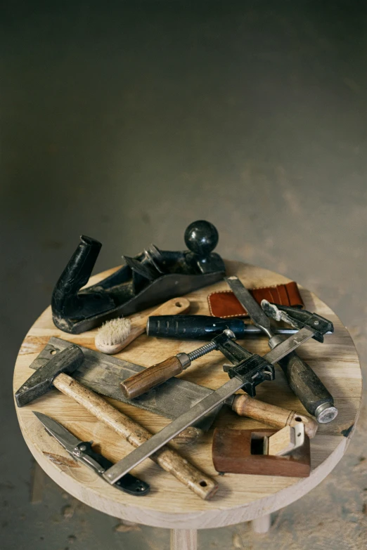 a variety of kitchen knives sitting on top of a wooden table