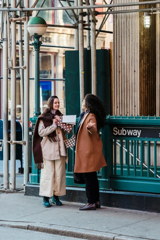 two women who are standing on the sidewalk