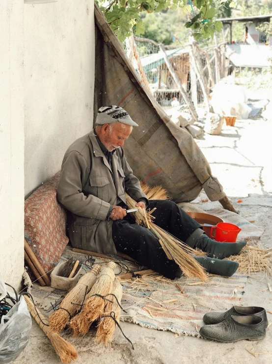 a man sitting on the ground next to several types of shoes