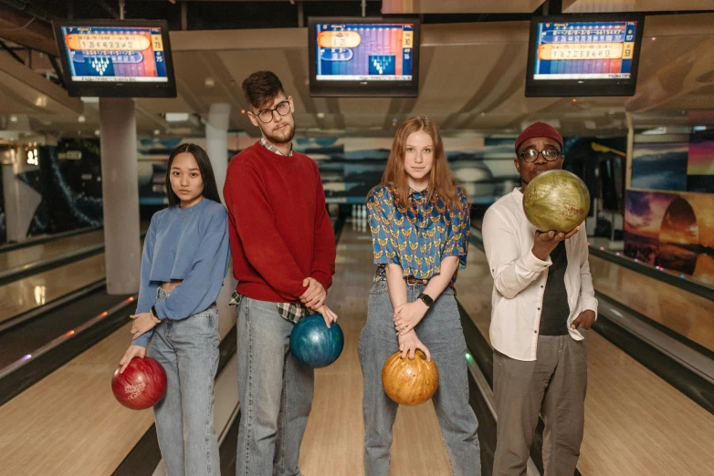 people in line with bowling balls on a long bowling alley