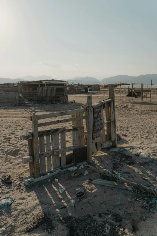 a fence made of old boards sitting in a dry desert area