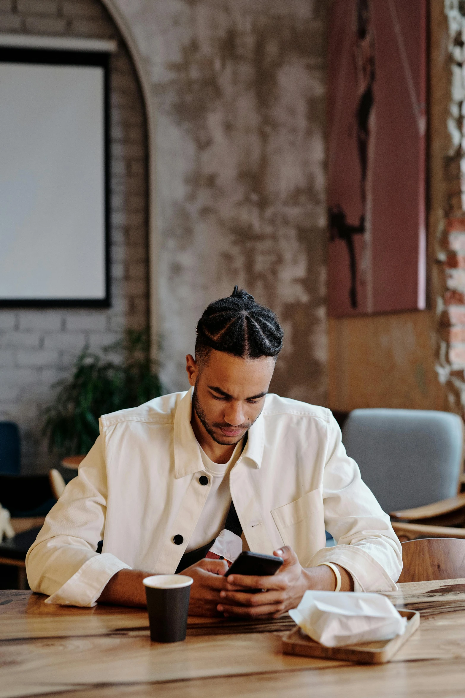 a man that is sitting down looking at a cellphone