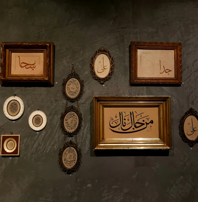 different framed pographs and arabic artwork on a wall