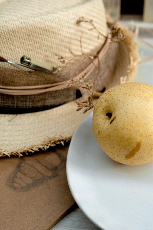 a yellow apple sitting on top of a white plate