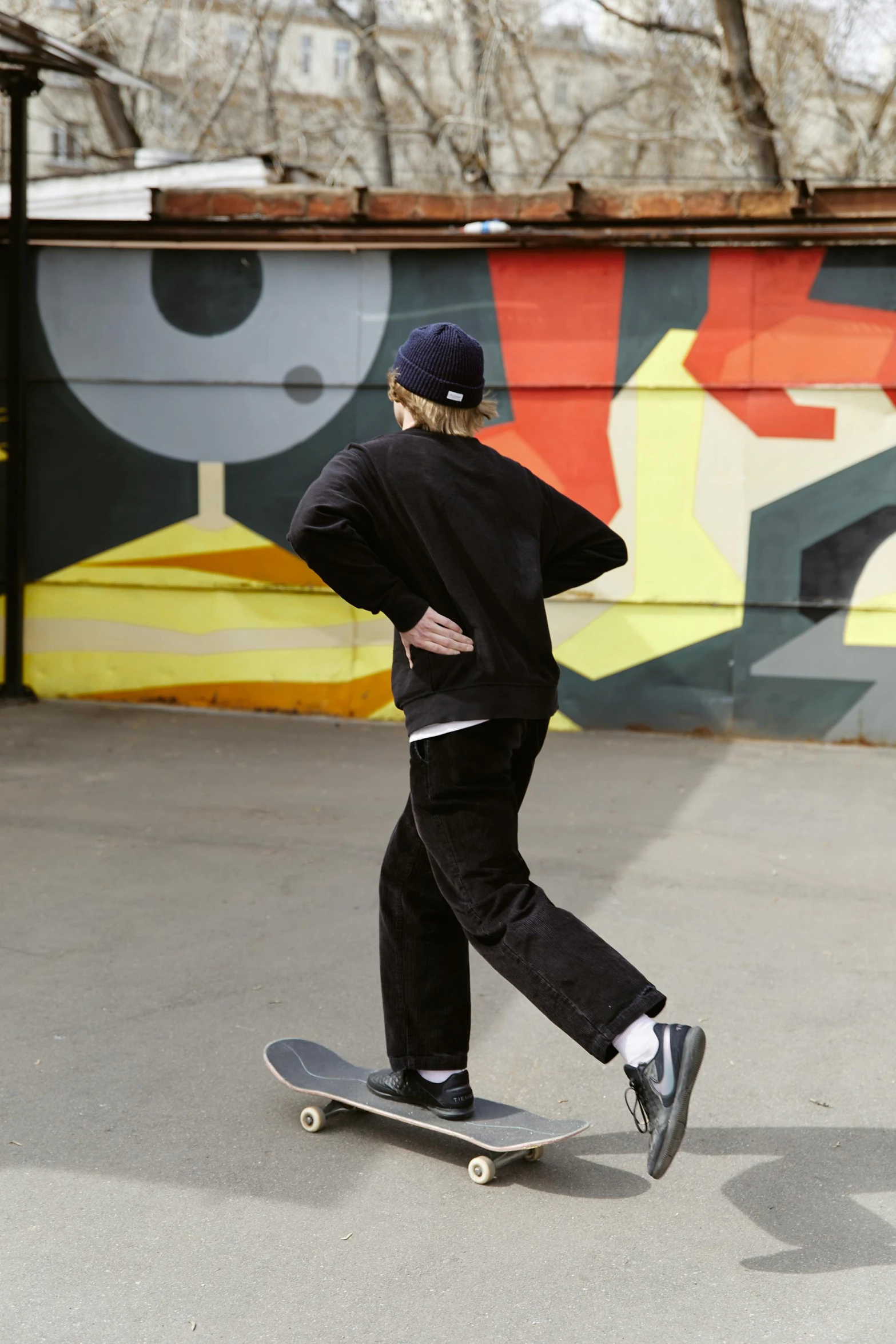 a man with a hat riding a skateboard