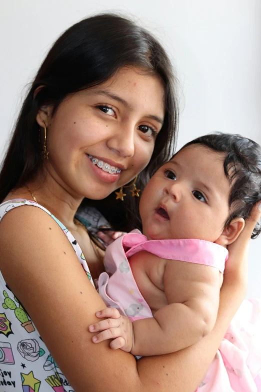 the woman holds her baby in her arms