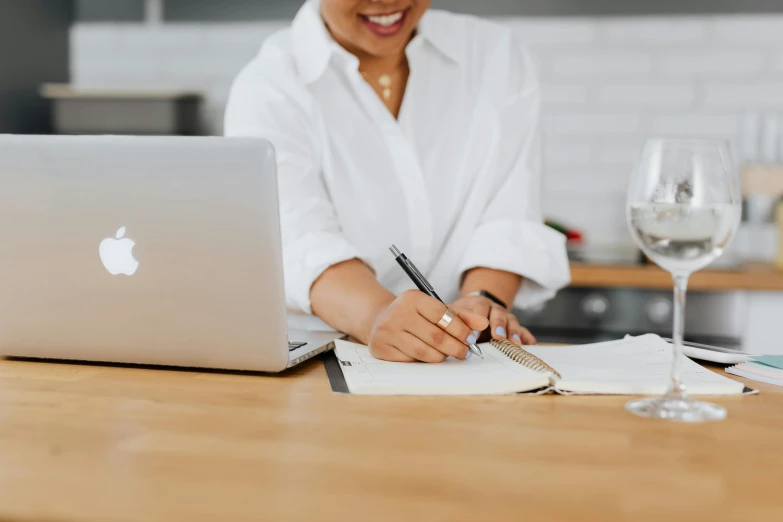 the smiling woman is doing her work on her laptop