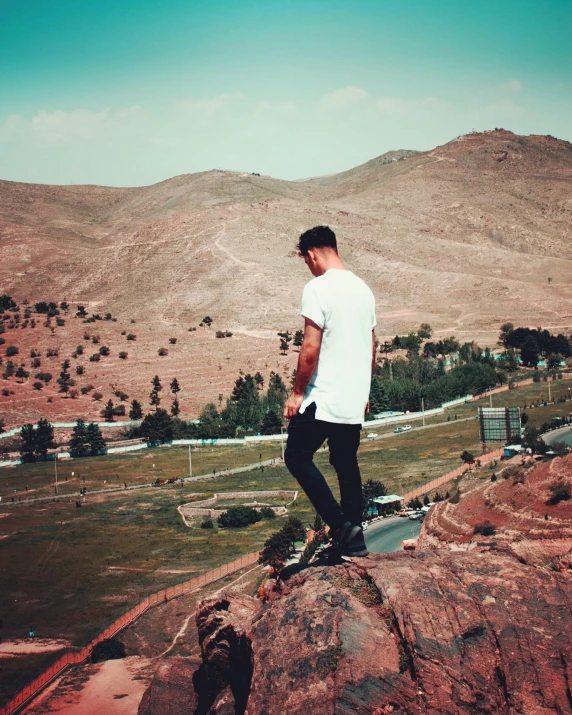 a man standing on top of a rock near a valley