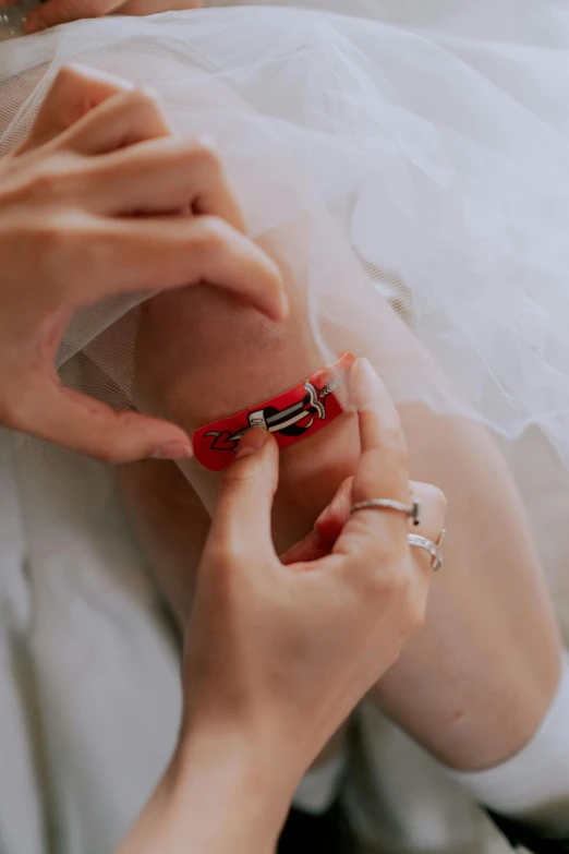 a bride in a white wedding dress fixing her ring