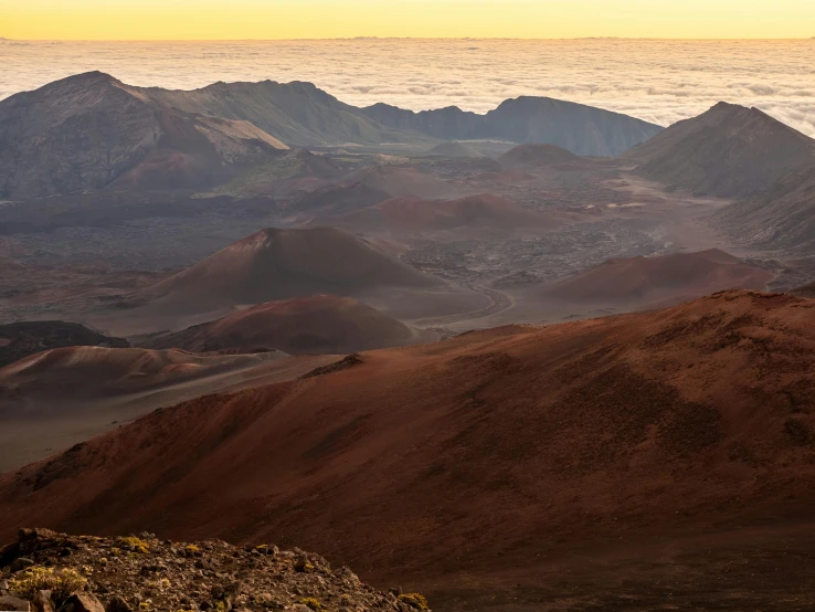 the top of a mountain with clouds in the distance