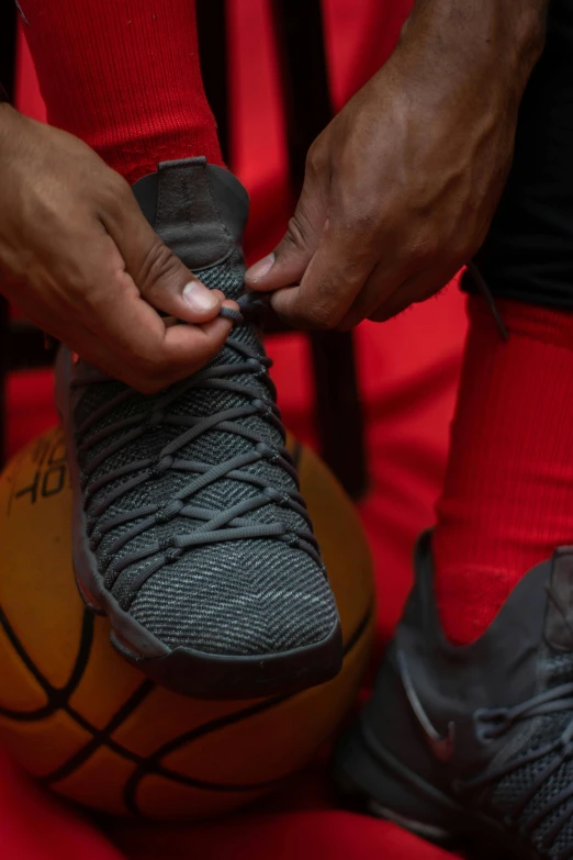 a close up of a basketball player tying their shoes