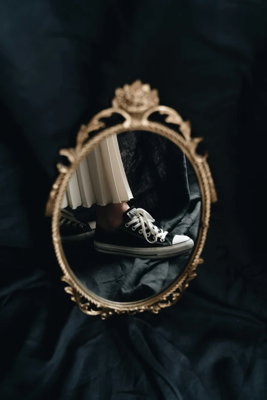 a person wearing black sneakers stands in front of a mirror