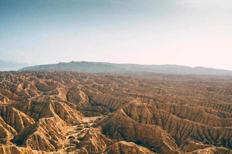 an aerial view of barren mountains with trees