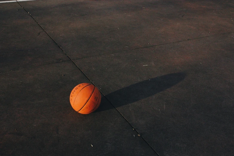 an orange basketball sitting on the ground near some cement