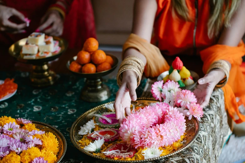 two people are decorating a table with flowers