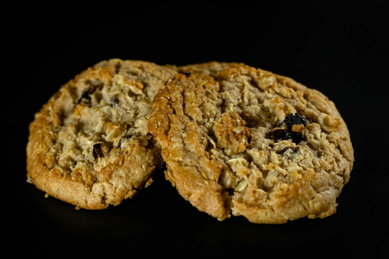 two cookies, one cut in half, with raisins on top