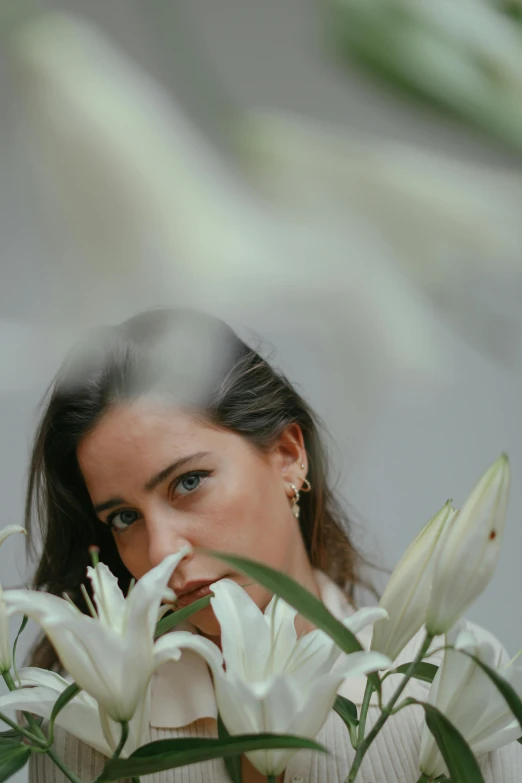 a woman is holding some flowers to her face