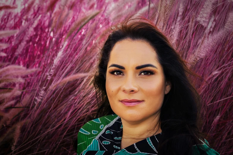 a woman with black hair and green and pink background