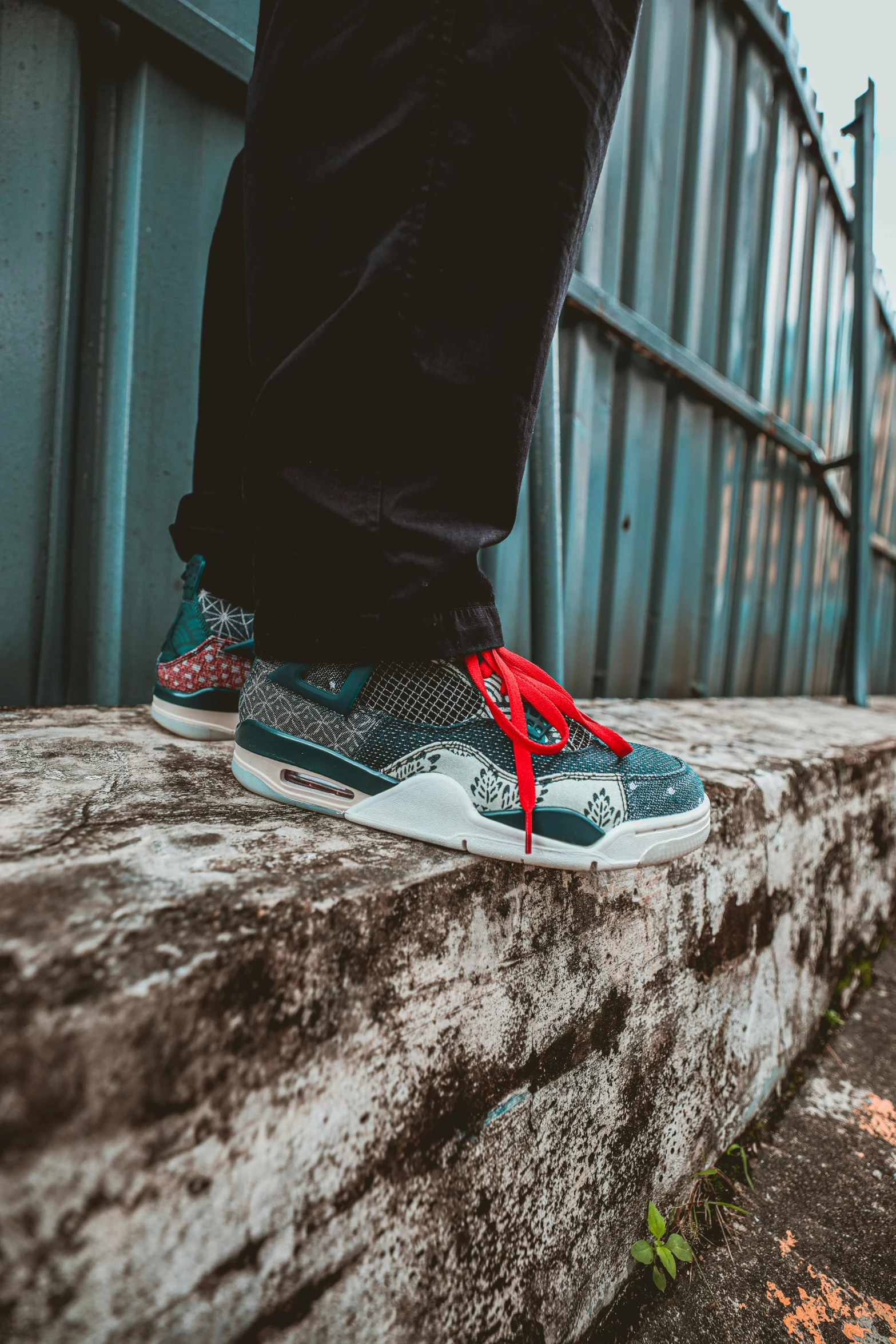 a man wearing red trainers on a side walk