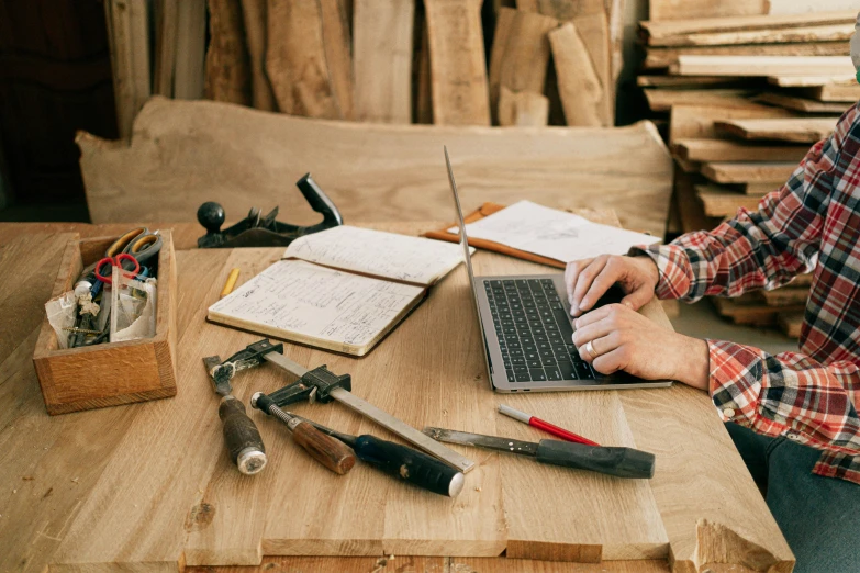 a person working on a laptop with office supplies nearby