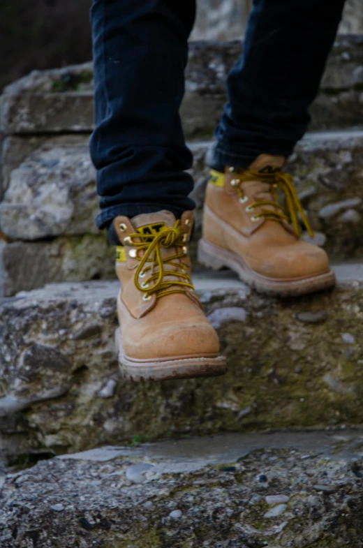 the person in brown boots is standing on rocks