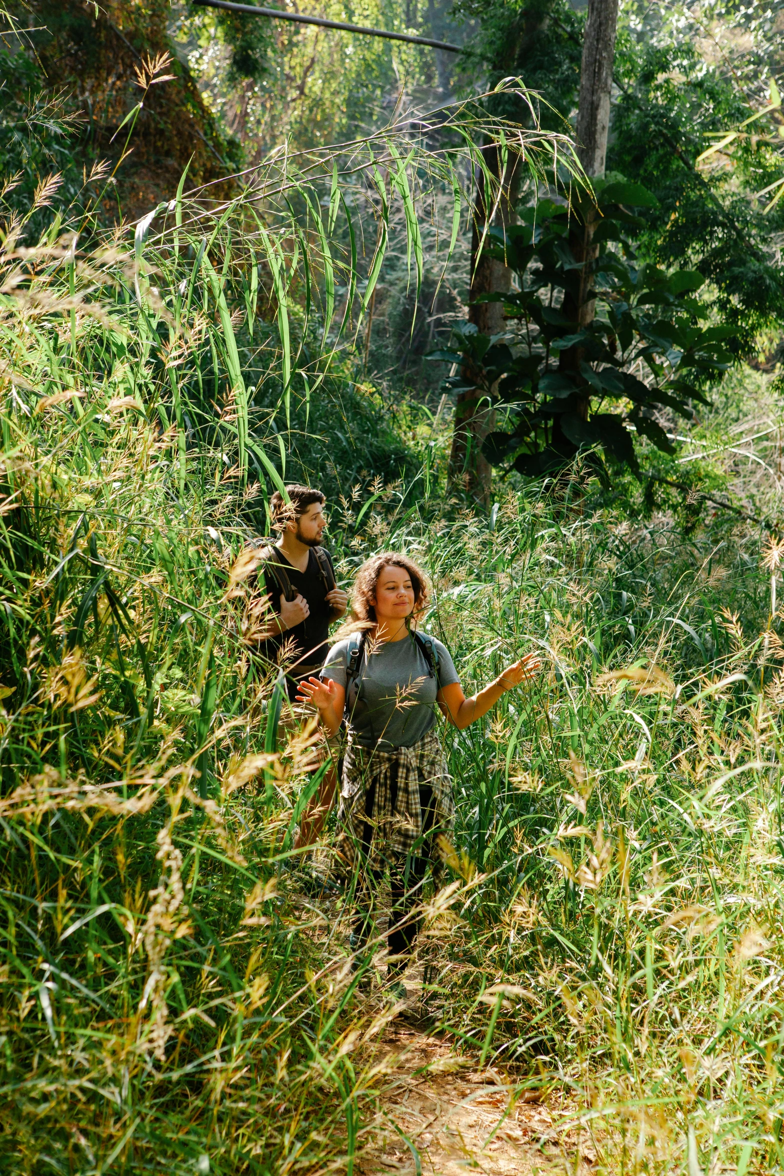 a girl walking through tall grass with a frisbee in her hand