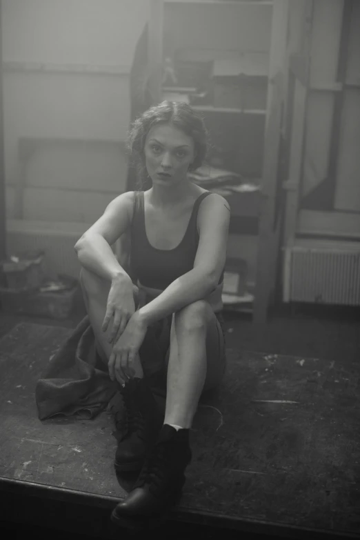 a black and white image of a woman sitting on the ground