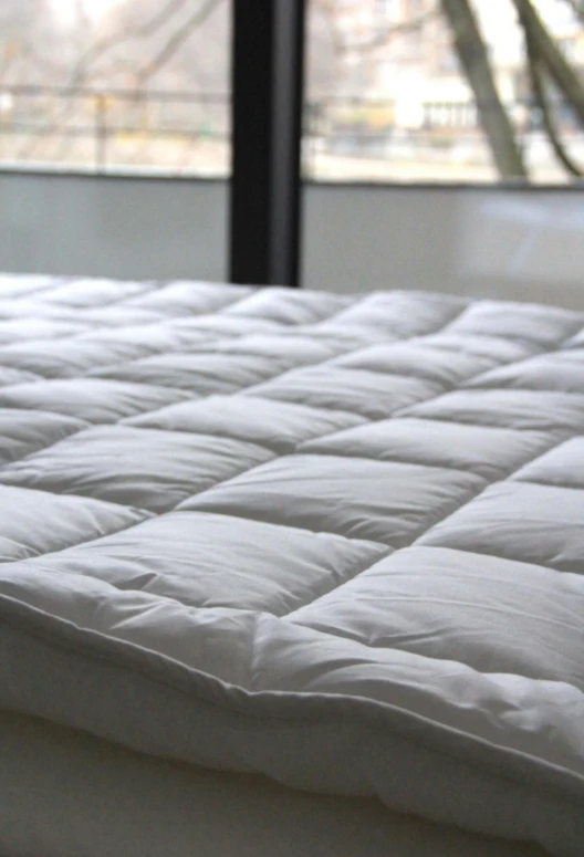 a mattress that is next to a window