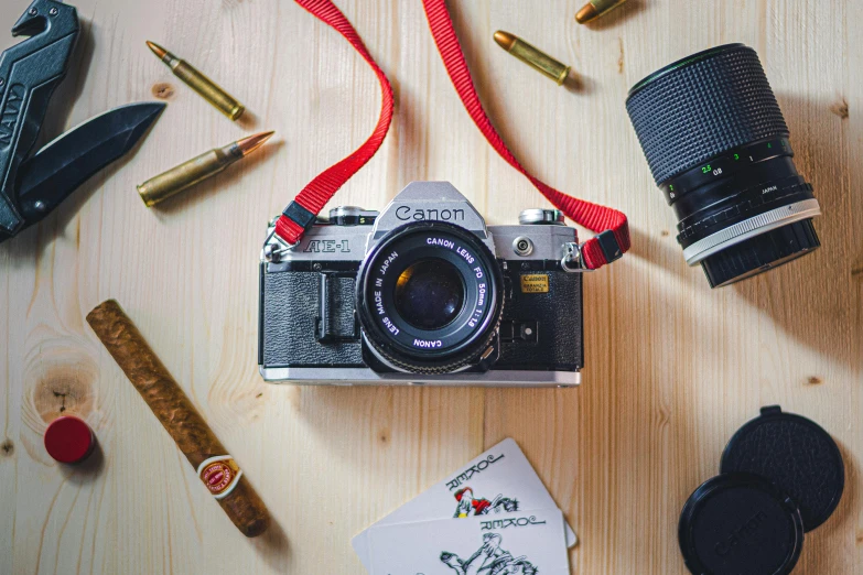 a camera, some cigars, and a pair of shoes are on the table