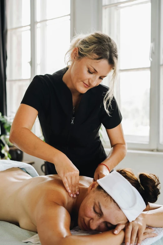 a woman receiving a back massage at a spa