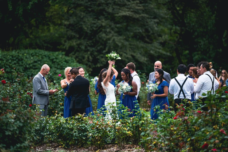 a wedding party and people standing around in a garden