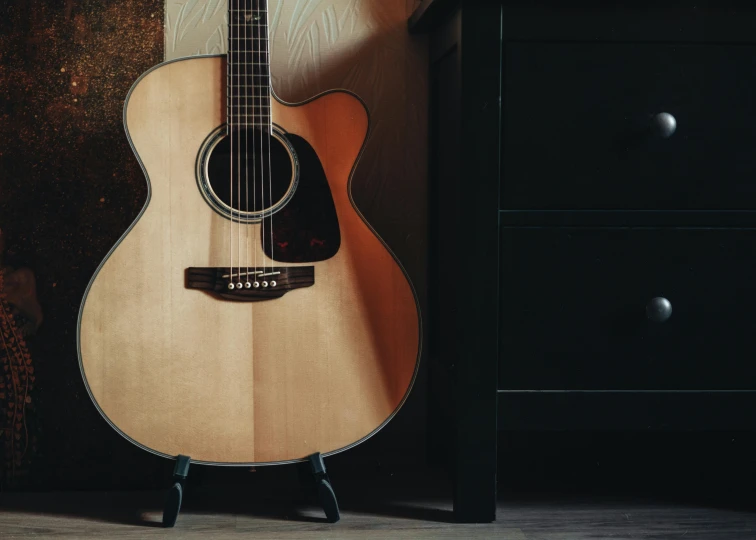 an old guitar resting on a wooden stand