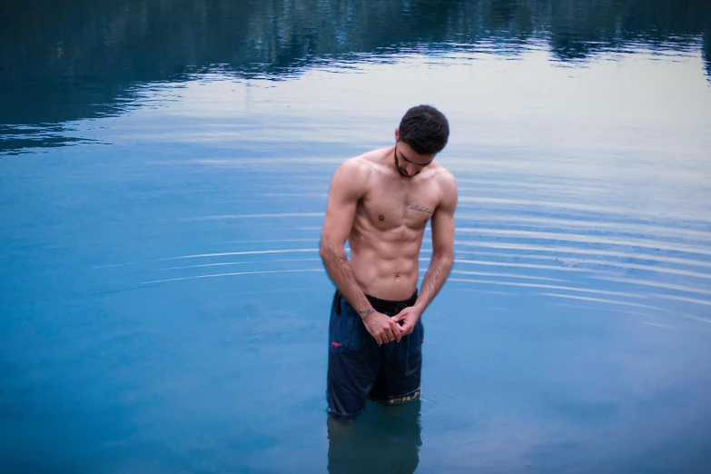 a man is standing in the middle of a body of water