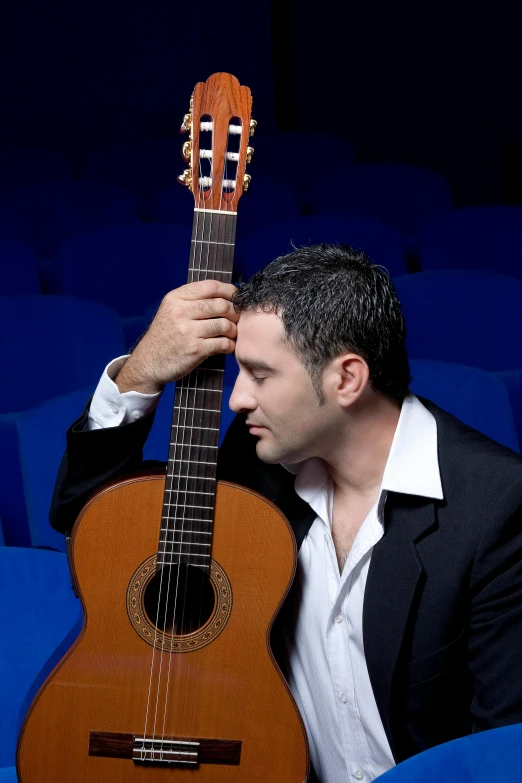 a man holding a guitar next to his head