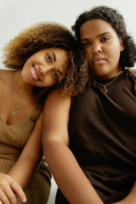 two women are hugging each other in front of a white background