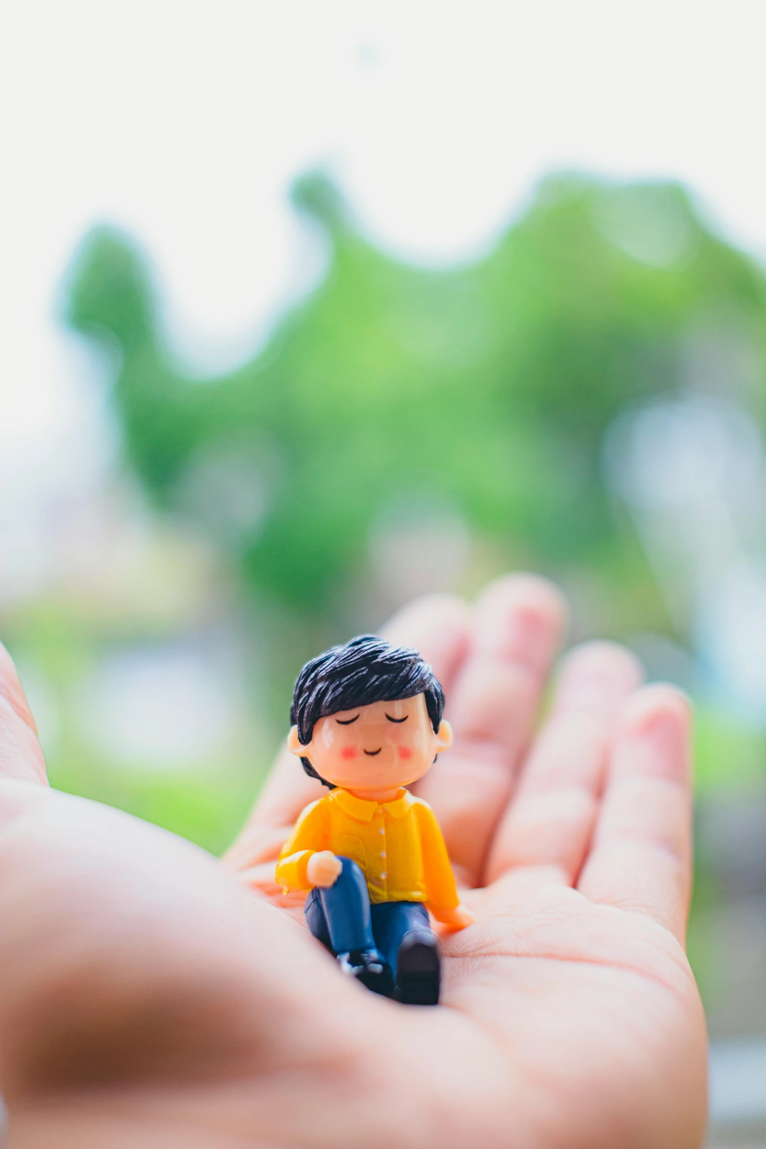 a small toy figurine in the palm of someone