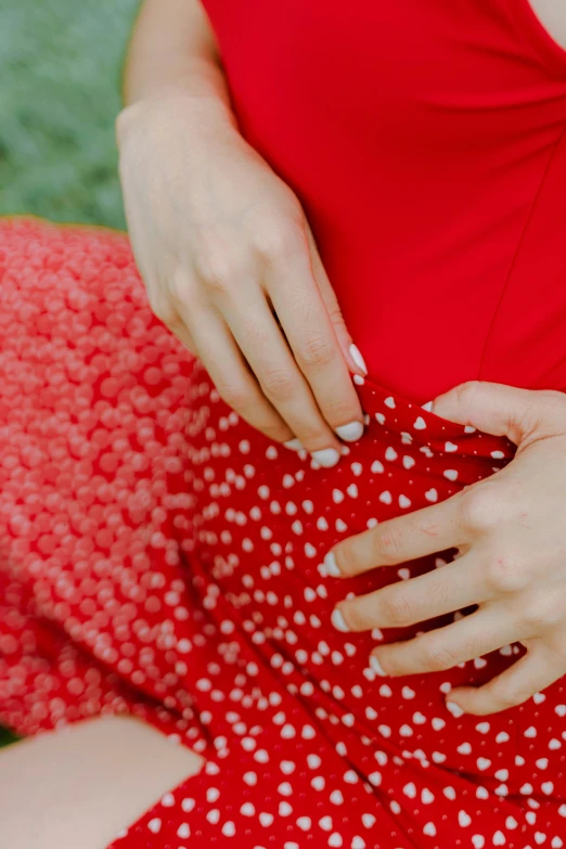 the woman is sewing her dress on the lawn