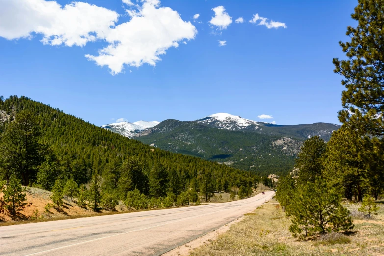 a scenic road is empty, with mountain range in the background