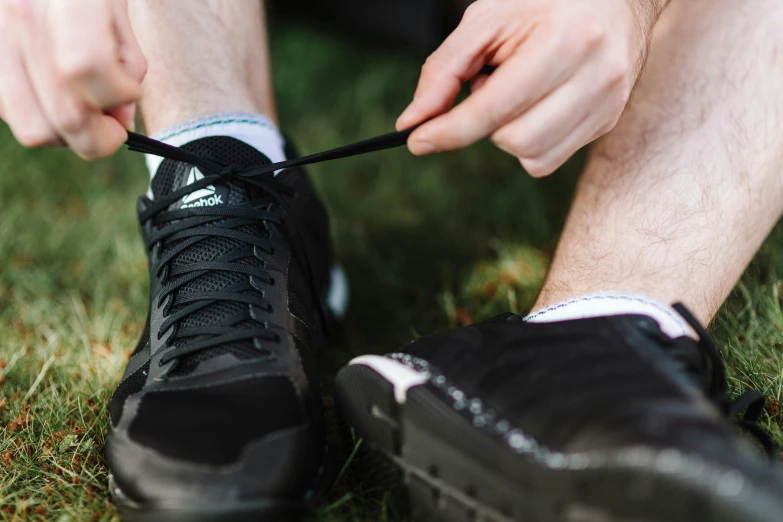 a person tying shoe laces to a running shoe