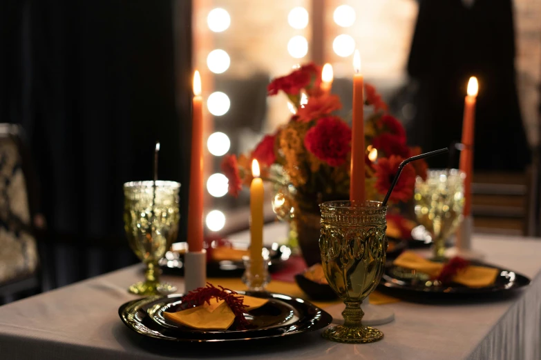 some black plates sitting on a table with candles