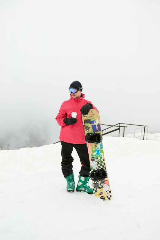 a man standing with his snowboard on a mountain