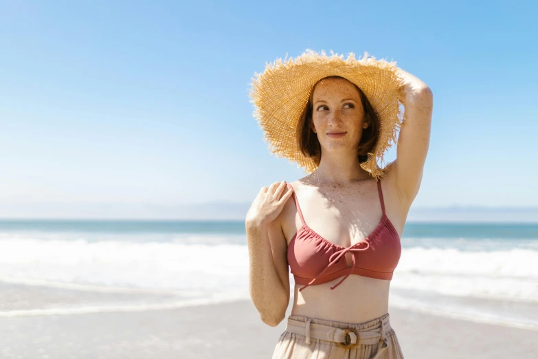 woman with sun hat at the beach in swim suit