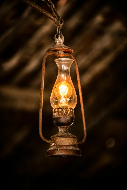 an old - fashioned lamp hanging from a rope