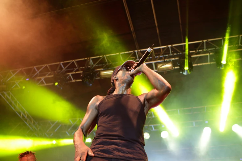 a man standing on stage singing into microphones