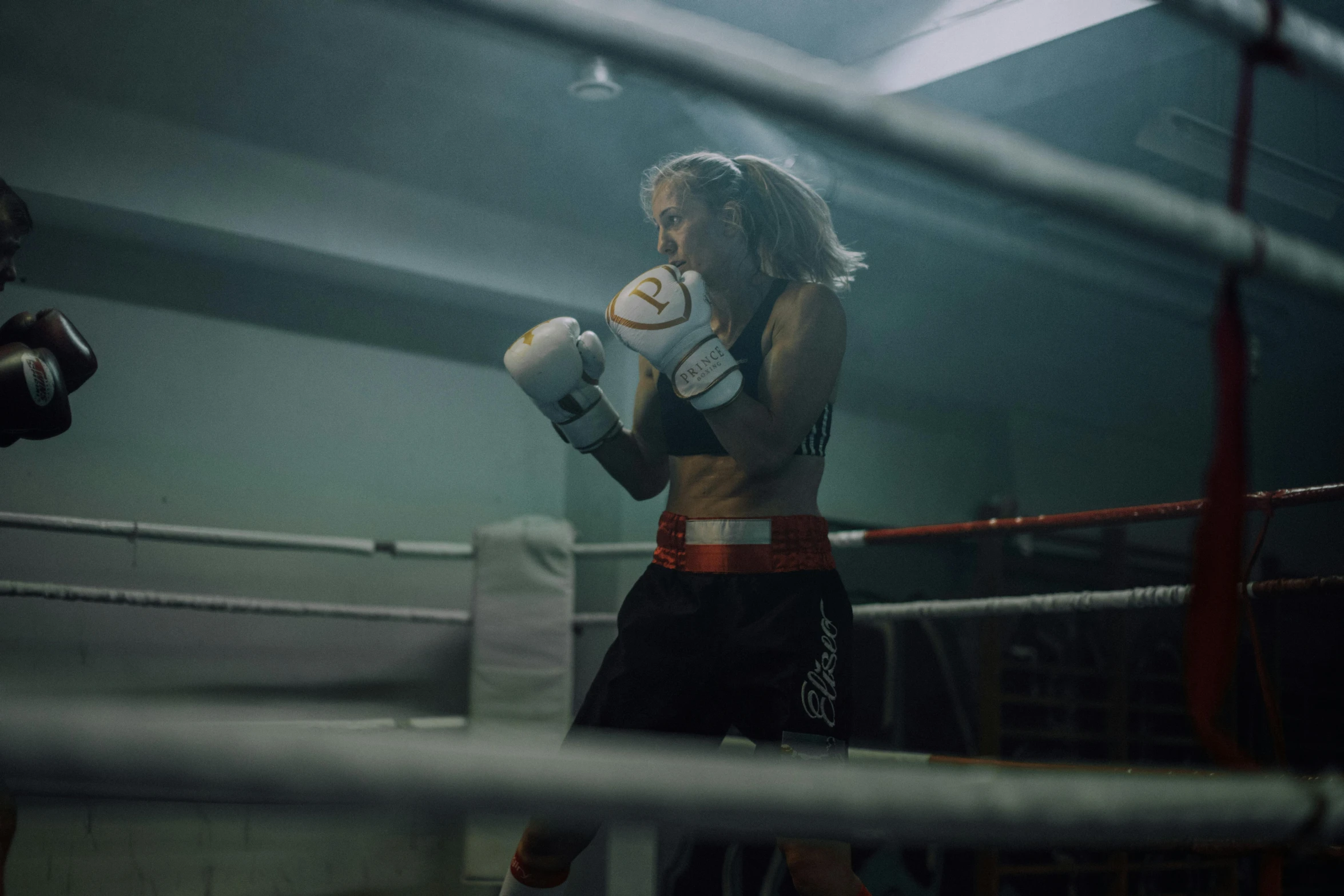 a woman boxing with a punching bag in a gym