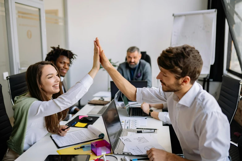 three people with their hands high, are making a team gesture