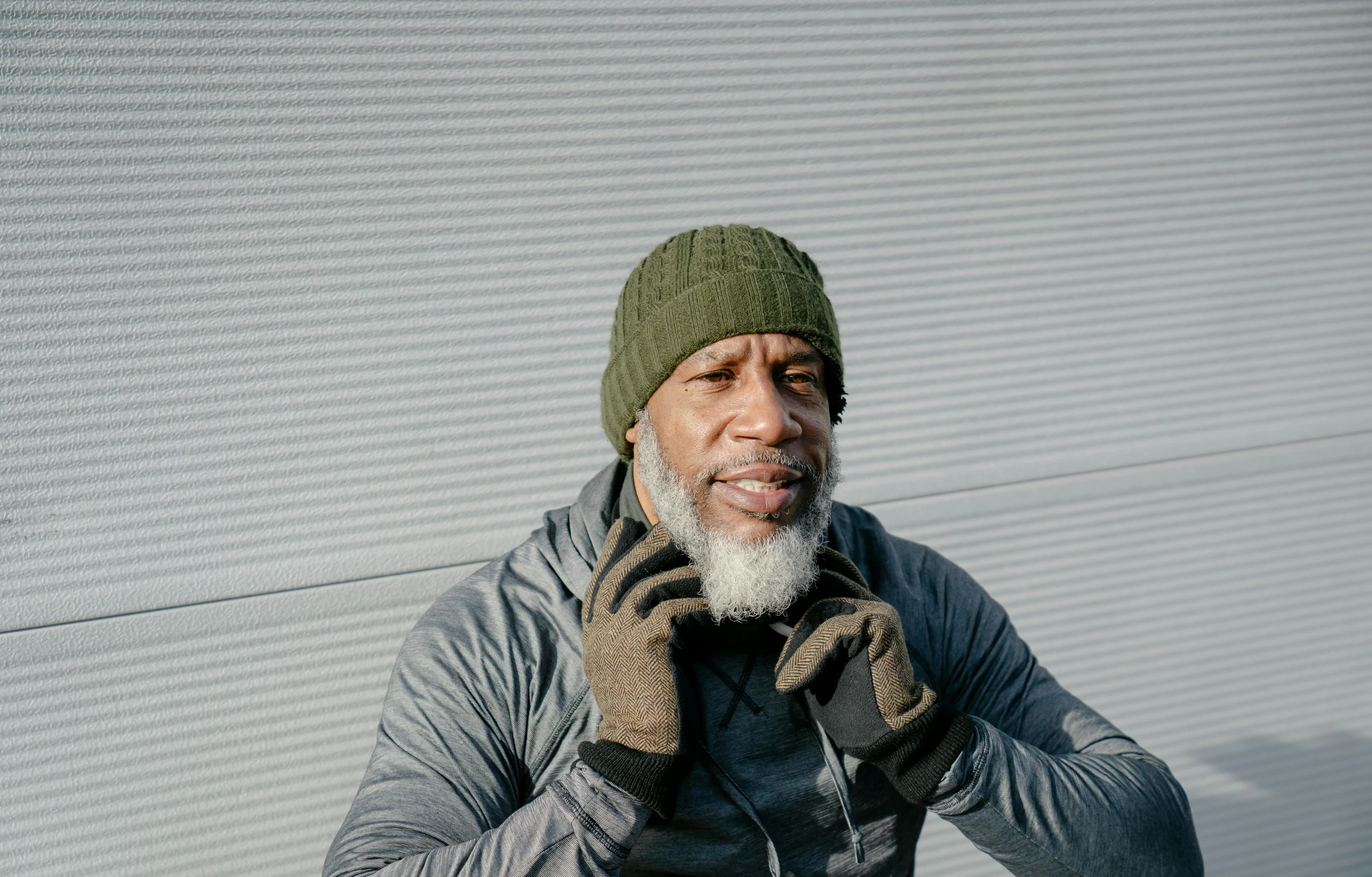 a man is talking on the phone wearing a knitted cap and sweater