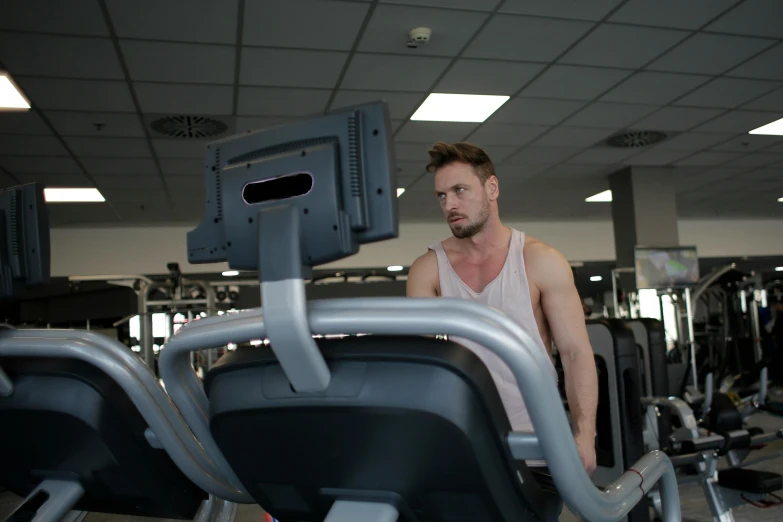 the man is on his exercise machines in the gym