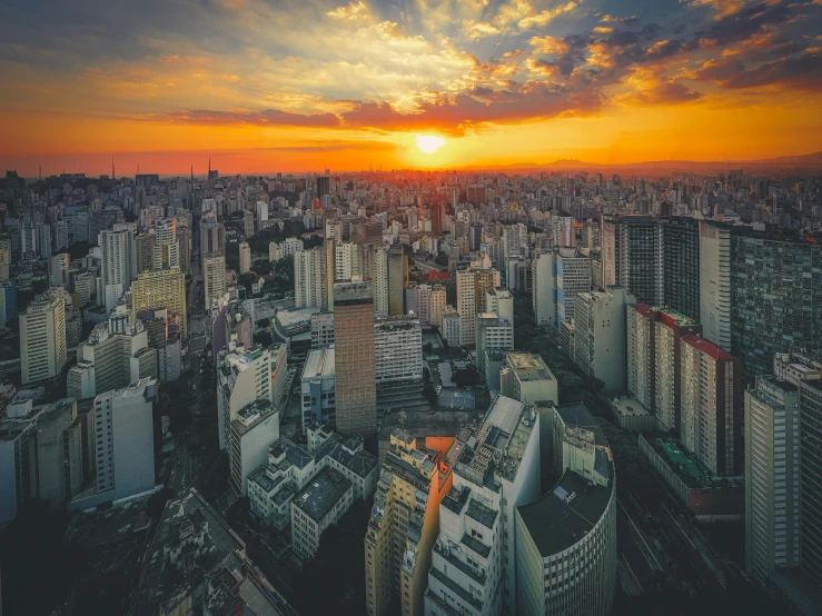 a skyline shows skyscrs against a colorful sunset