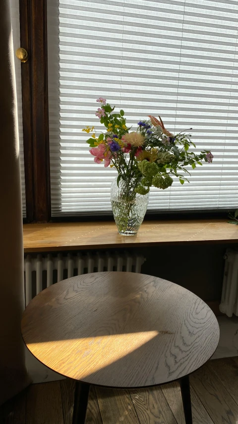 a table and vase sit near the window